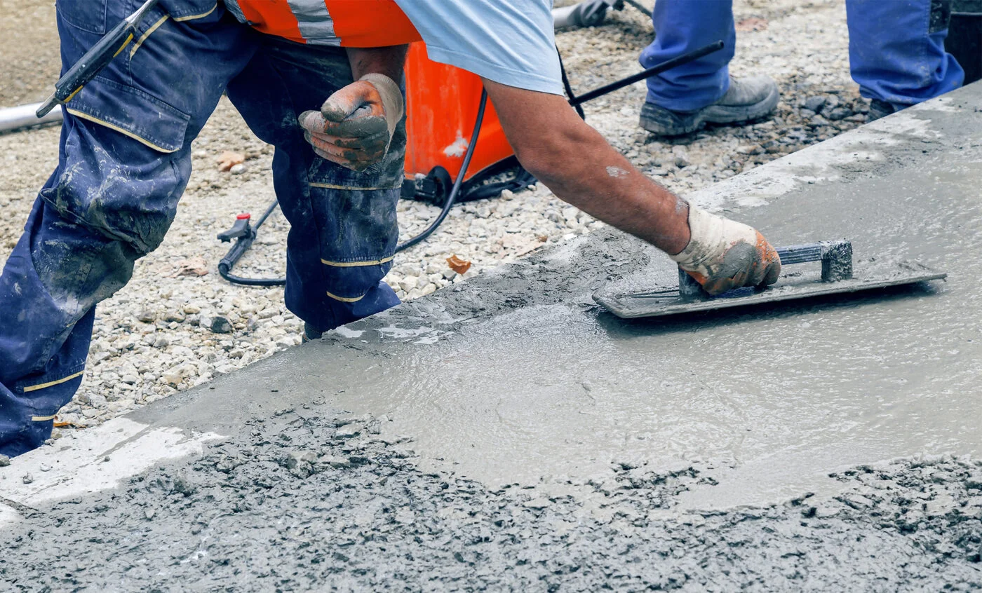 Concrete professionals pouring and finishing a commercial slab on a jobsite